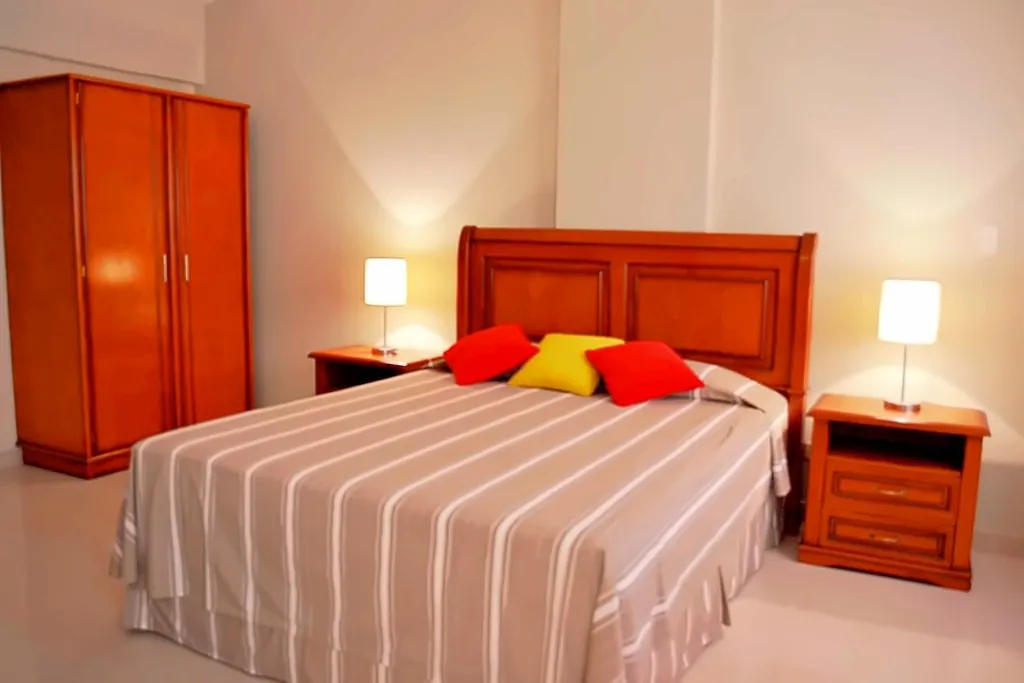 Apartamento superior con cama doble y cojines de color