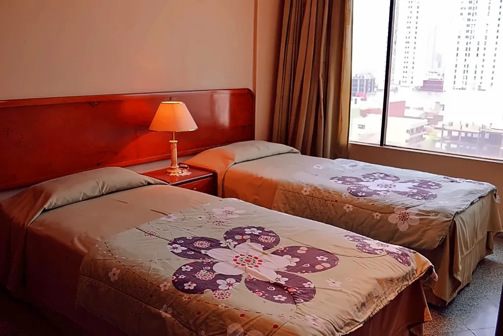 Habitación con dos camas individuales y cubrecamas florales